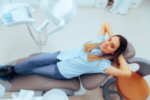 Happy Patient Sitting Comfortable in a Dental Office. Carefree relaxed woman sitting in a dentist cabinet with no fear